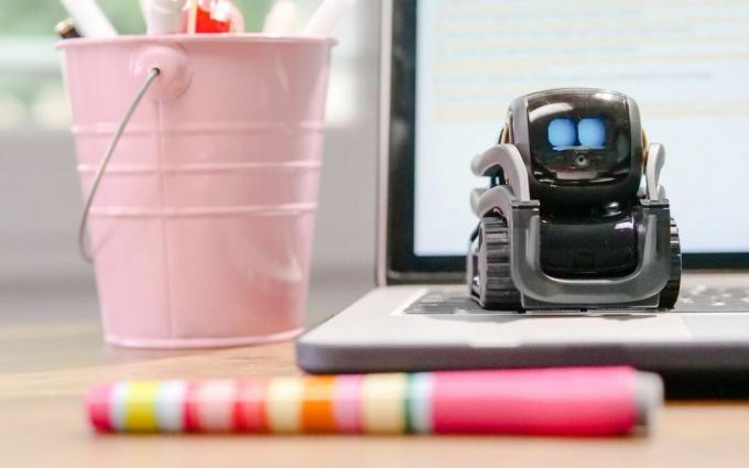 Robot jucărie miniatural pe partea de sus a tastaturii laptopului