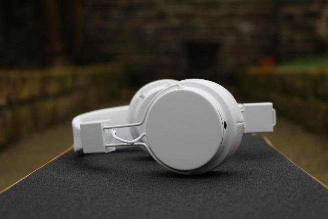 Căști Urbanear Plattan 2 Bluetooth pe un skateboard din lateral