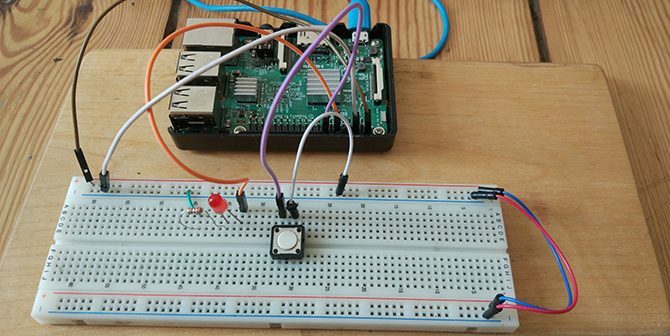 Raspberry Pi s-a agățat până la un buton și LED-ul pe o placă de pâine.