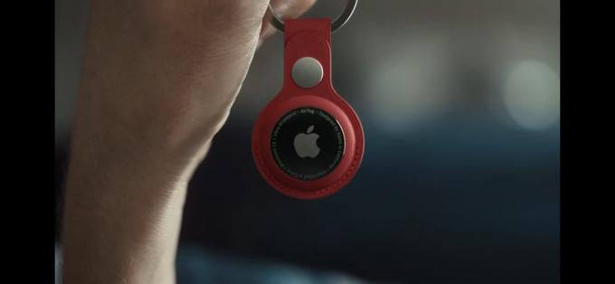 Apple AirTag pe Keychain roșu în mână.